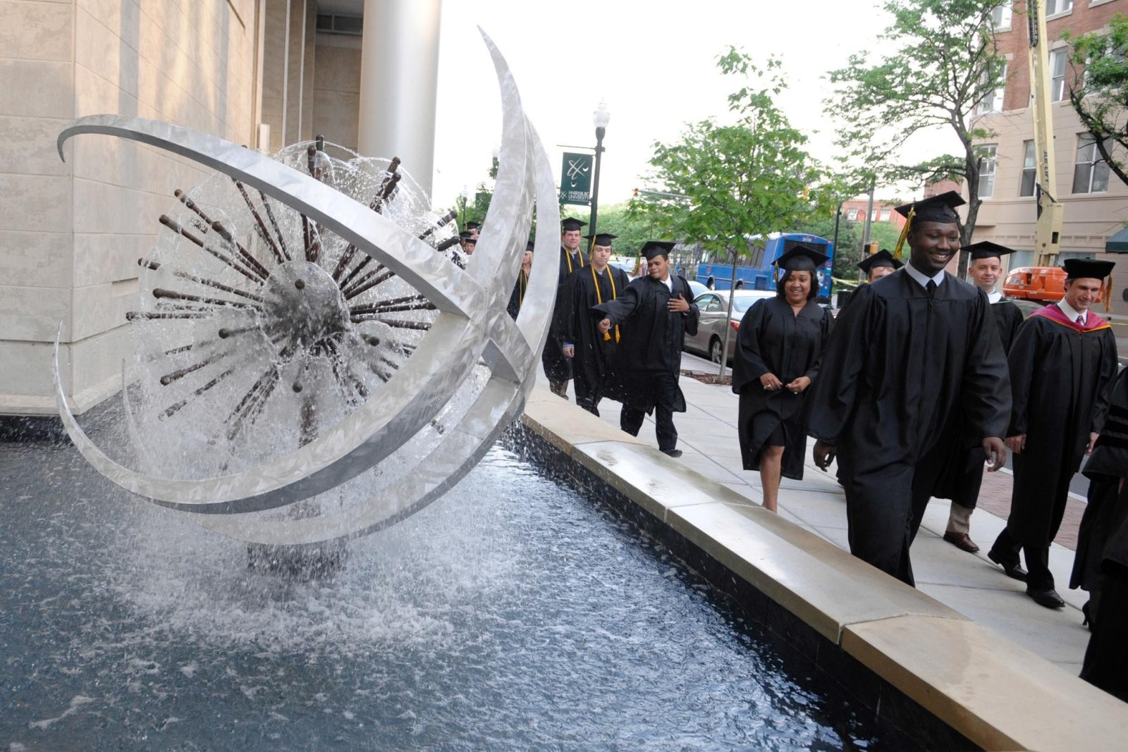 Graduates walking past fountain