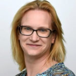 a person with glasses smiling