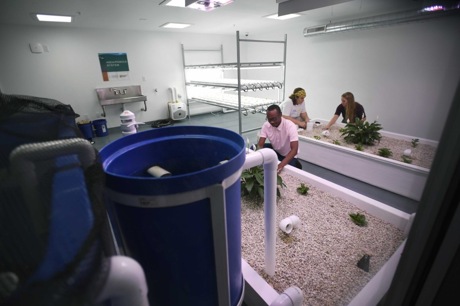 a group of people sitting in a room with blue buckets