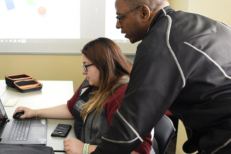 a man and a woman looking at a laptop