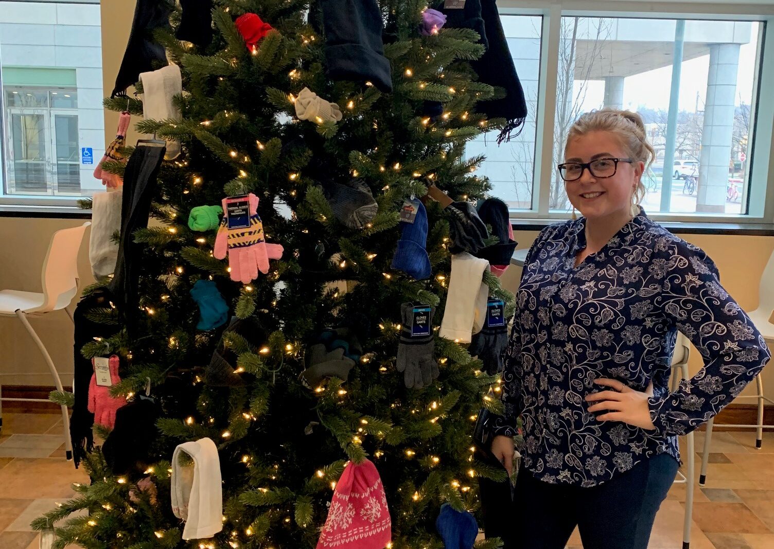 a person standing next to a christmas tree