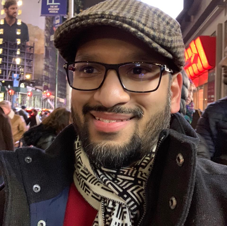 a man wearing glasses and a hat