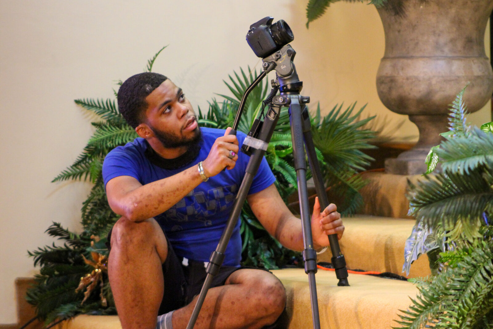 a man sitting on a chair holding a large camera