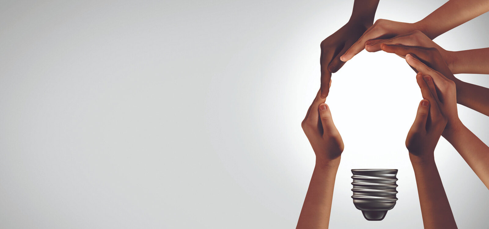 a close-up of hands reaching for a light bulb