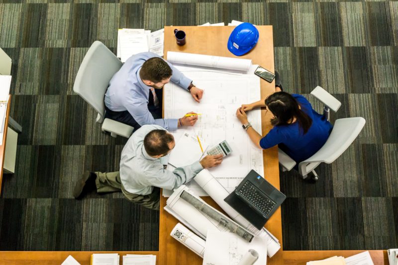 a man and a woman sitting at a table with plans