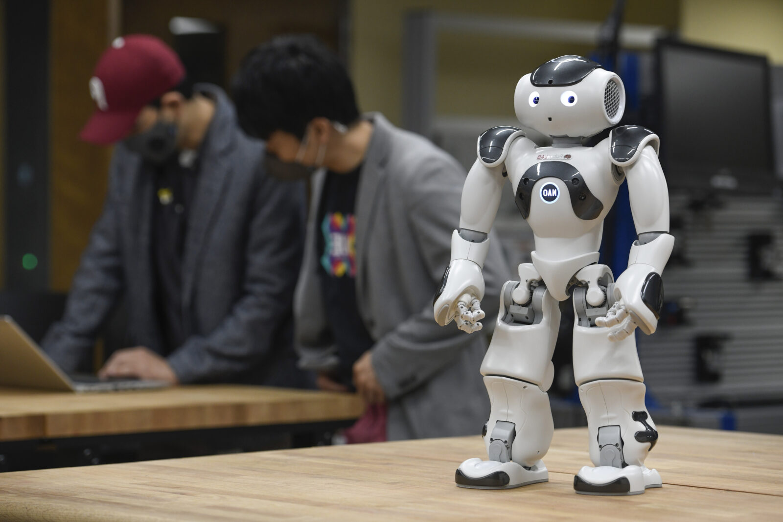 two people next to a robot